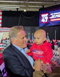 Mike Rogers, Candidate for U.S. Senate in Michigan holding a baby.