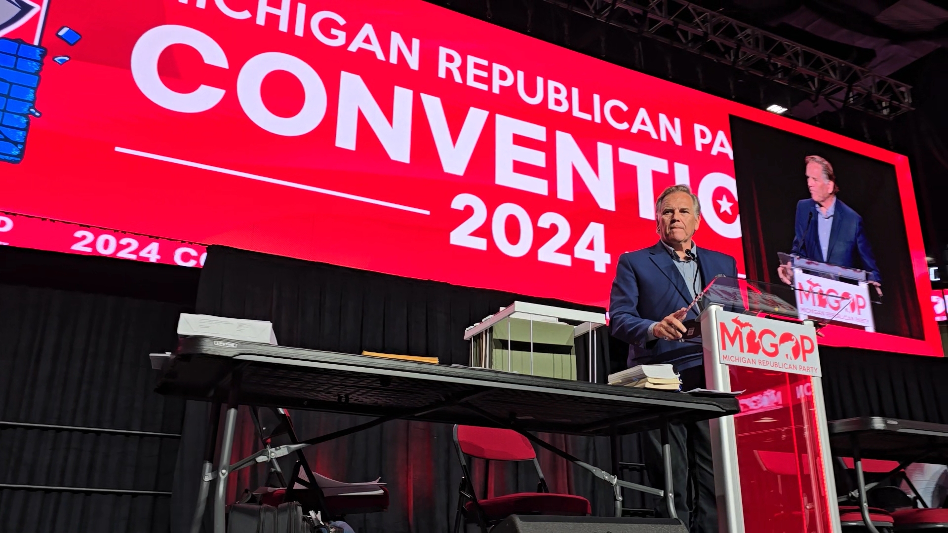 Mike Rogers speaking on stage at a Michigan Republican Party convention