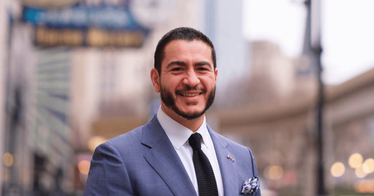 Abdul El-Sayed wearing a blue suit in an urban setting.