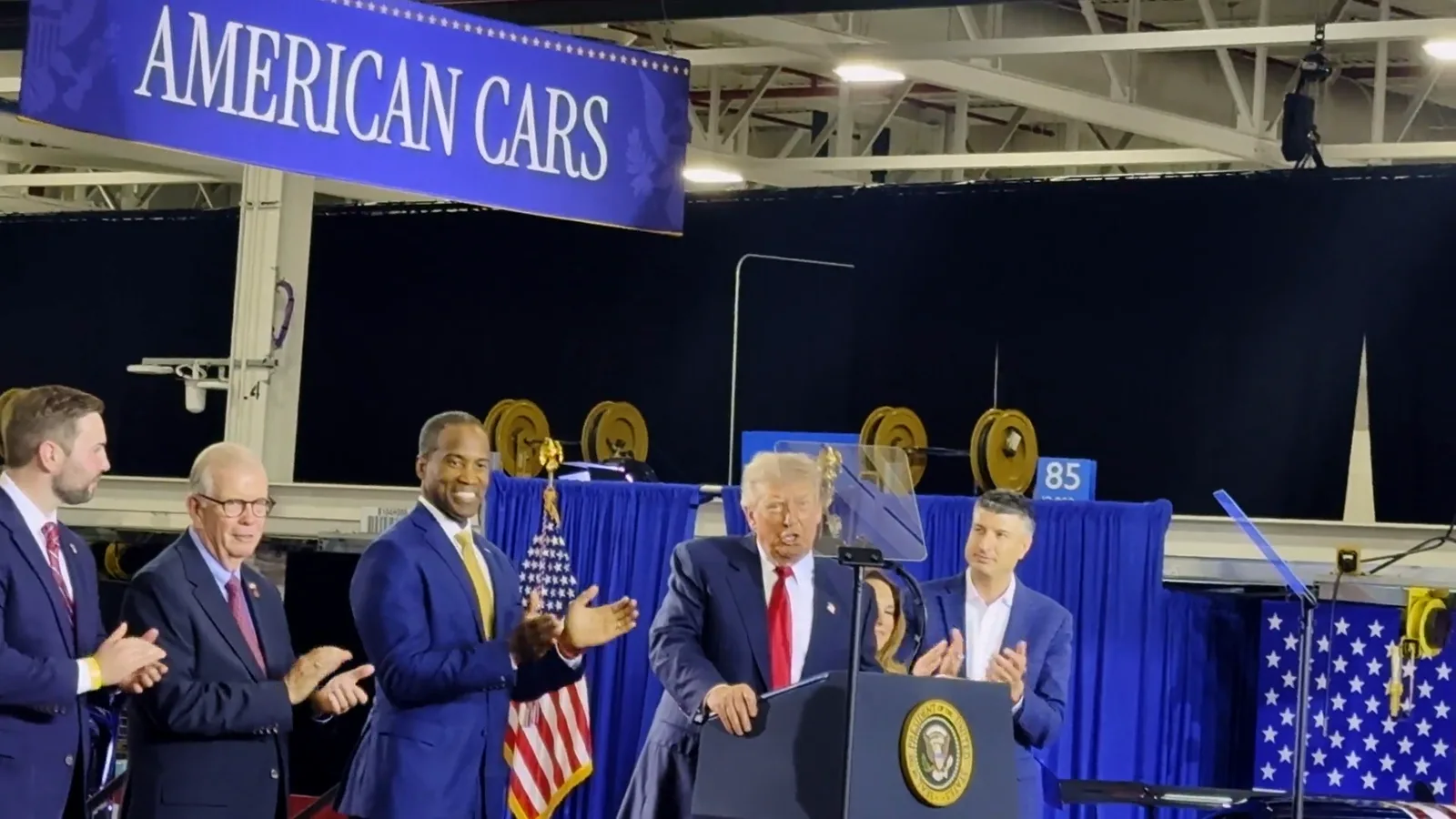 Donald Trump and Michigan Republican figures on stage at GM’s Milford Proving Ground