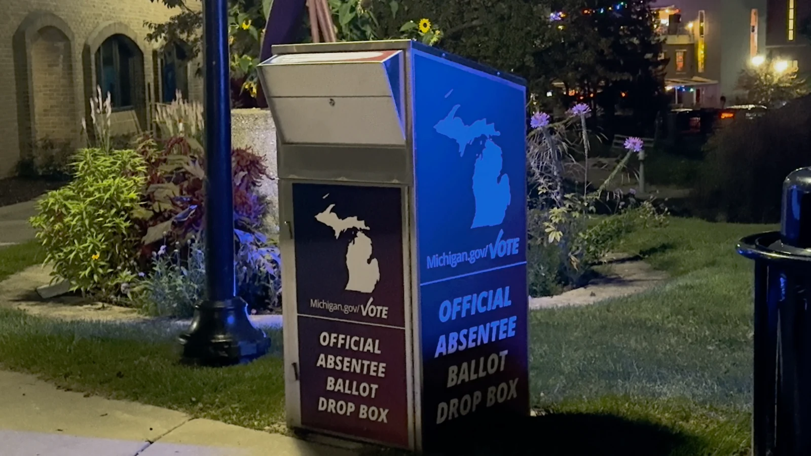 A Michigan absentee ballot drop box illuminated at night.